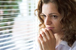 women with anxiety looks out the window. She gets counseling for women in bradenton, fl at forever free counseling to help her overcome imposter syndrome