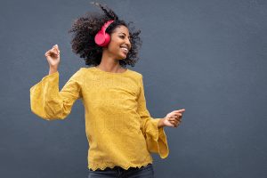 happy woman dances with headphones on. She went to counseling for women in bradenton, fl to overcome perfectionism tendencies at Forever Free Counseling