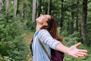 happy woman hiking in the woods after anxiety treatment in bradenton, fl with therapist Elizabeth Jordan at forever free counseling