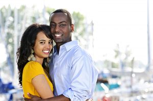 happy black couple smiles at the camera in a marina after premarital counseling in bradenton, fl at forever free counseling 34203
