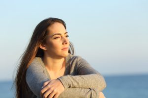 thoughtful woman on the beach before going to anxiety treatment in Bradenton FL at forever free counseling