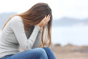 worried teen on the beach before getting anxiety treatment in Bradenton, FL from therapist Elizabeth Jordan at Forever Free Counseling